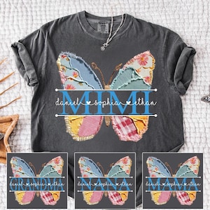 May include: Dark grey t-shirt with a patchwork butterfly design. The butterfly has the word "MIMI" in the centre, with the names "daniel", "sophia", and "ethan" above and below the butterfly. The t-shirt has a round neck.