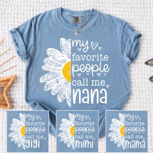 May include: A pale blue t-shirt featuring the text "my favourite people call me Nana" and a daisy design. The shirt also has three smaller images with the text "Gigi", "Mimi", and "Mama".