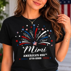 Puede incluir: Una camiseta negra con un gráfico de fuegos artificiales rojos, blancos y azules que irradian desde una estrella central. El diseño incluye los nombres William, Jennifer, Angela, Robert, Melissa y Kathleen, con el texto Mimi, America's 250th y 1776-2026.