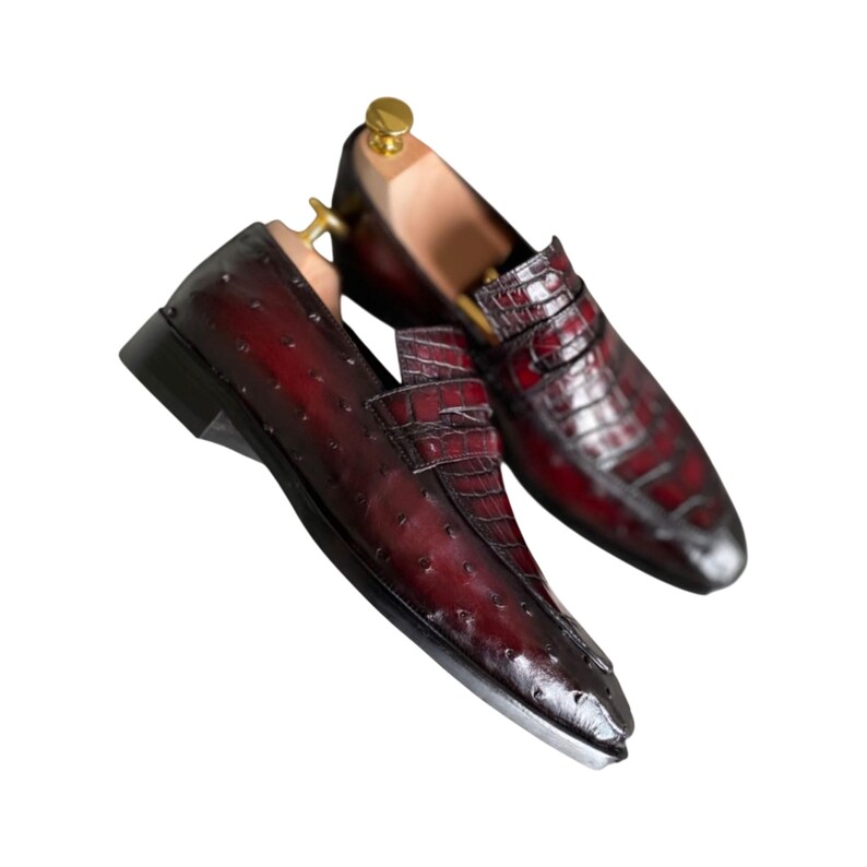 Handcrafted men's burgundy crocodile pattern loafers with brass shoe tree inserts and decorative keeper bar. Premium dress shoes featuring exotic leather texture. Perfect gift for weddings, anniversaries, executives, or special occasions.