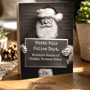 Könnte beinhalten: Schwarz-Weiß-Grußkarte mit dem Weihnachtsmann, der ein Schild mit der Aufschrift "North Pole Police Dept. Multiple Counts of Illegal Chimney Entry" hält. Das Bild hat einen Vintage-Stil im Fahndungsfoto-Stil.