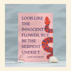 May include: A pink poster with the quote "Look like the innocent flower, but be the serpent under't" by Lady Macbeth. The poster features a red and purple snake illustration. A seashell and small white flowers are in the foreground.