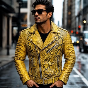 May include: A bright yellow motorcycle jacket with a black snakeskin pattern, featuring a wide notched collar, silver-tone metal zippers, a diagonal front closure, a buckled waist belt, and quilted detailing on the sleeves, worn over a black shirt.