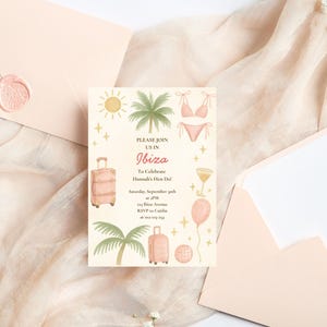 Puede incluir: Una tarjeta de invitación de color beige claro con ilustraciones de acuarela para una despedida de soltera en Ibiza. La tarjeta presenta una maleta, palmeras, un bikini y el texto "PLEASE JOIN US IN Ibiza". La invitación está rodeada de sobres y tela color melocotón.
