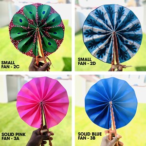 May include: Four hand fans, two small and two large. The small fans are patterned, one with a green and red design and the other with a blue and white design. The large fans are solid colors, one pink and one blue.