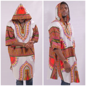 May include: A white hooded tunic with a colorful geometric pattern. The tunic has a long, flowing design and a hood with a drawstring. The pattern features orange, red, yellow, green, and purple colors.