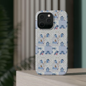 May include: A phone case featuring a repeating pattern of Eeyore from Winnie the Pooh. The design includes light blue squares with Eeyore illustrations, bows, and floral accents on a white background. The case has a glossy finish and a camera cutout.
