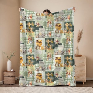 Puede incluir: Una manta suave de patchwork verde y blanco con Winnie the Pooh y sus amigos. El diseño incluye imágenes de Pooh, Piglet, Eeyore y tarros de miel. La manta tiene un patrón repetitivo con el texto "What if I fall? Oh, but my darling, what if you fly?"