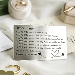 Könnte beinhalten: Eine rechteckige silberfarbene Metallkarte für das Portemonnaie mit eingraviertem schwarzem Text: When I say I LOVE YOU more, I don't mean I LOVE YOU more than you love me, I mean I LOVE YOU more than the bad days ahead of us, I LOVE YOU more than any fight we will ever have. I LOVE YOU more than the distance between us, I LOVE YOU more than any obstacle that could Try and come between us. I love you most, inklusive Herzgrafik.