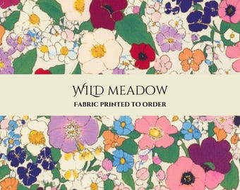 May include: A fabric print featuring a dense pattern of colorful wildflowers in shades of red, pink, purple, orange, blue, and white on a cream background. The text WILD MEADOW FABRIC PRINTED TO ORDER is centered in a horizontal cream band.
