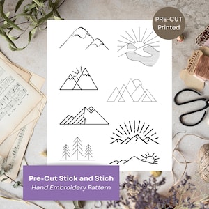 Pode incluir: Uma folha branca com vários desenhos de montanhas e sóis em arte de linha preta. A folha está rotulada como "Pre-Cut Stick and Stich Hand Embroidery Pattern" e "Pre-Cut Printed". Também há tesouras, linha e partituras.