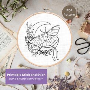 Op de afbeelding: Een zwart-wit handborduurpatroon met een mot, maan en bloemenontwerp. Het ontwerp wordt weergegeven in een houten borduurring. De tekst "PDF Pattern" staat rechtsboven en de tekst "Printable Stick and Stich Hand Embroidery Pattern" onderaan.