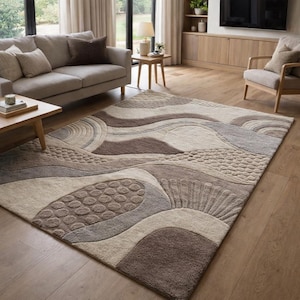Può includere: Un grande tappeto rettangolare con un design astratto strutturato nei toni del marrone, beige e grigio. Il tappeto presenta un motivo a onde con sezioni in rilievo e un aspetto morbido e soffice. Adatto per un soggiorno o una camera da letto.