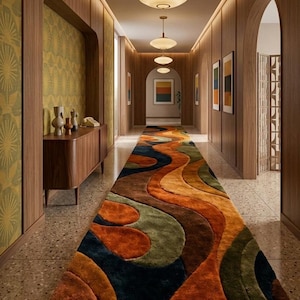 Puede incluir: Un pasillo con una alfombra estampada y colorida en tonos naranja, marrón, verde y azul. Las paredes son de paneles de madera con puertas arqueadas y obras de arte. Encima, hay varias lámparas colgantes.