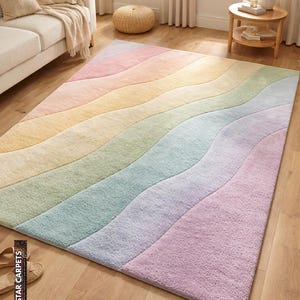 Può includere: Un tappeto rettangolare caratterizzato da un motivo ondulato multicolore in delicate tonalità pastello di rosa, giallo, verde, blu e viola. Il tappeto presenta una superficie a pelo lungo e testurizzato su un pavimento in legno chiaro.