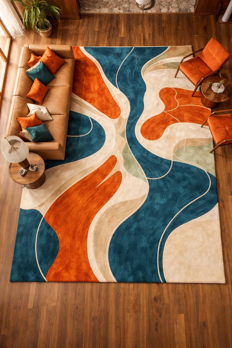 May include: A large rectangular area rug featuring a bold, abstract pattern of flowing, organic shapes in vibrant shades of deep teal, burnt orange, and cream. The design consists of sweeping, curved lines that create a dynamic, layered effect.