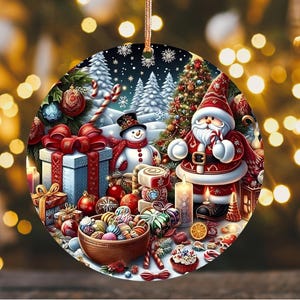 May include: A round Christmas ornament featuring a festive winter scene. Santa Claus, a snowman, and a decorated Christmas tree are surrounded by gifts, candy canes, and ornaments. The ornament has a gold string for hanging.