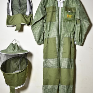 May include: A green beekeeping suit with a matching hood and hat. The suit has a checkered pattern and multiple pockets. The hood and hat have mesh netting for protection. The suit is hanging on a metal hanger.