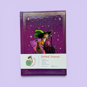 May include: A purple hardback journal featuring a gold-foiled illustration of a stoat bard with a lute and hat. A white paper band displays the text Dotted Journal, A5 Journal, 208 dotted pages, 100 gsm, back pocket, ribbon bookmark, and happy_stoat.