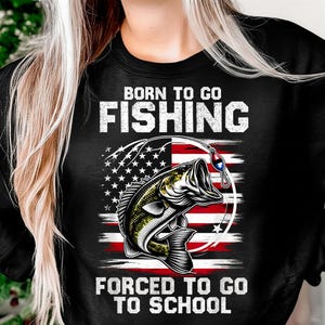 May include: Black sweatshirt with the text "BORN TO GO FISHING FORCED TO GO TO SCHOOL". The design features a fish, fishing hook, and an American flag design in red, white, and blue.