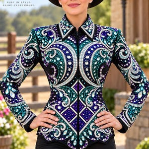 May include: A black long-sleeved show shirt featuring a high collar and a full-length front zipper. The garment is heavily embellished with intricate swirling patterns in shades of teal, purple, and white, accented by numerous sparkling crystals.