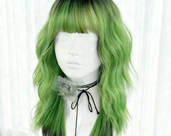 May include: A green and black wig with wavy texture and bangs. The wig is styled on a mannequin head, with a black choker necklace featuring a gray flower and black ribbon. The wig's color gradient transitions from black at the roots to vibrant green.