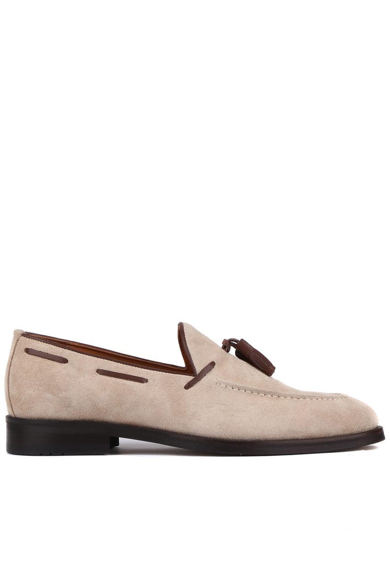 Op de afbeelding: Beige su&egrave;de loafer met een donkerbruine zool en afwerking. De schoen heeft een decoratieve kwast en gestikte details. Een klassieke instapper voor dagelijks gebruik.