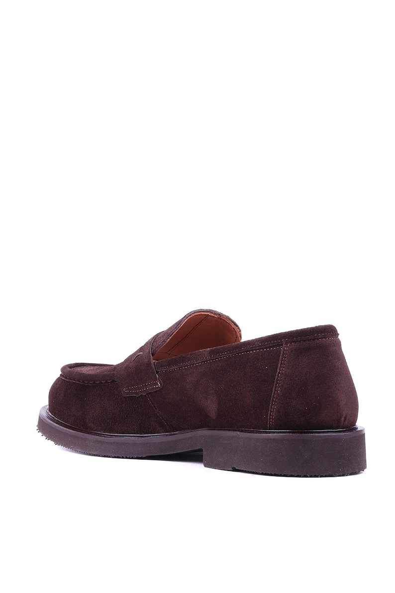 May include: Brown suede loafer with a rounded toe and a low, stacked heel. The shoe features a slip-on design with a strap detail across the vamp. The sole is a darker brown color.