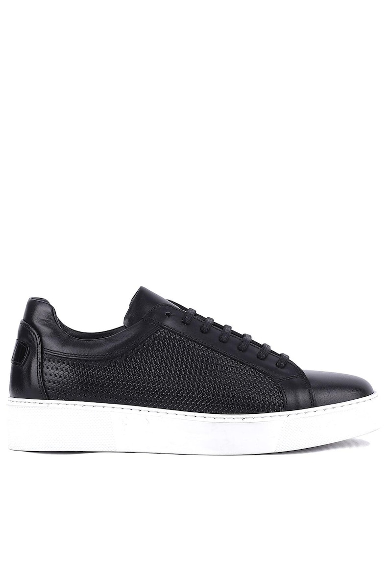May include: Black leather sneaker with a white sole. The shoe features a woven texture on the side panel and a smooth leather upper. The laces are black, and the sole is approximately 1 inch thick.