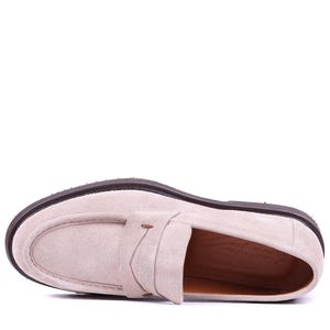 May include: A single light beige suede loafer with a dark brown sole. The shoe features a classic penny loafer design with a strap across the vamp. The sole is approximately 1 inch thick.