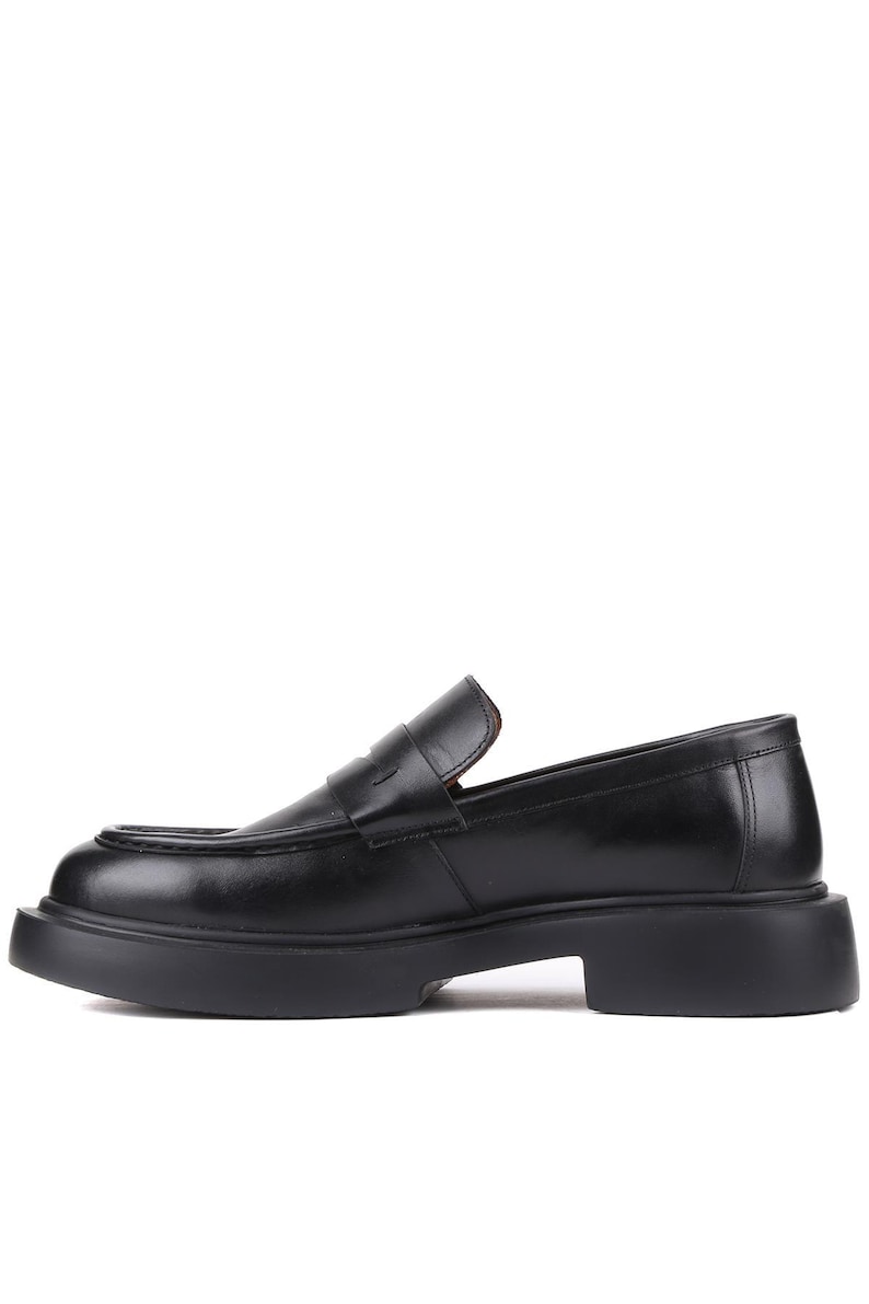 Puede incluir: Mocas&iacute;n de cuero negro con suela gruesa. El zapato presenta un dise&ntilde;o cl&aacute;sico de mocas&iacute;n con punta redonda y tac&oacute;n bajo. El zapato est&aacute; hecho de cuero liso y brillante y tiene un dise&ntilde;o minimalista.