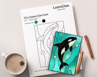 May include: Orca stained glass panel, 6.5 x 8 inches, featuring a black and white orca against a teal and turquoise background. The panel has a black border and includes bubbles. A line drawing of the orca is on a white sheet.