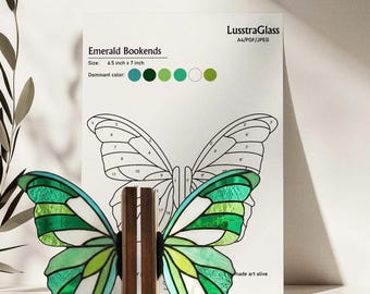 May include: Emerald butterfly bookends with a stained glass design in shades of green and white. The bookends are 6.5 inches x 7 inches and sit on a wooden base. A diagram of the butterfly is in the background.