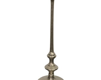 Può includere: Un tavolino laterale in metallo color argento con piano rotondo e stelo sottile e decorativo. Lo stelo presenta una serie di accenti arrotondati e anche la base è rotonda. Il tavolo è progettato per uso decorativo.
