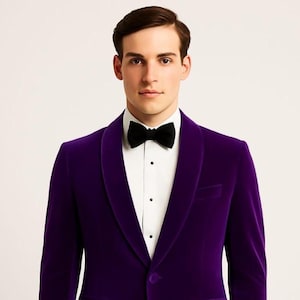 Może przedstawiać: Formalna fioletowa aksamitna marynarka z czarną muchą i białą koszulą. Marynarka ma szalowy kołnierz i zapięcie na jeden guzik. Strój jest odpowiedni na specjalną okazję.