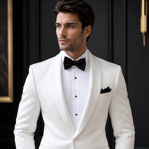 Könnte beinhalten: Ein weißes Smoking-Sakko mit Schalkragen und einem dazu passenden weißen Hemd mit verdeckter Knopfleiste und Plisseefalten. Das Outfit wird durch eine einfarbige schwarze Fliege und ein schwarzes Einstecktuch elegant ergänzt.