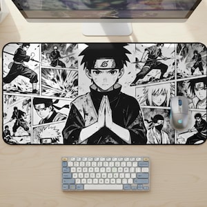 Puede incluir: Alfombrilla de ratón de estilo manga en blanco y negro con un personaje central con las manos juntas en oración, rodeado de paneles de acción. El diseño incluye un ratón inalámbrico y un teclado compacto, adecuado para una configuración de escritorio.