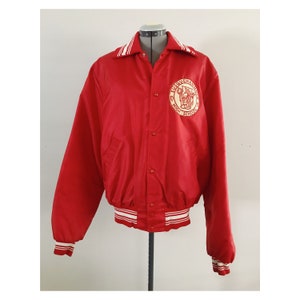 May include: Red satin varsity jacket with white and red striped trim. The jacket has a button closure and features a large embroidered patch on the left chest that says "Susquehanna High School" with a graphic of a horse and rider.