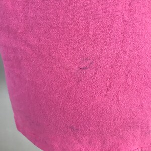 May include: A pink t-shirt with a slight fade in the colour. The shirt is made of a soft, comfortable fabric.