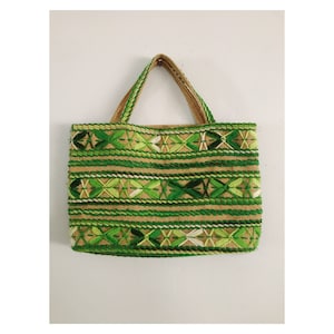 May include: A green and brown woven tote bag with a geometric pattern. The bag has two handles and is made of a natural material.