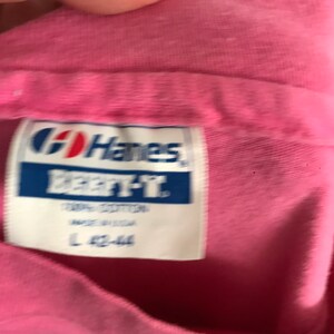 May include: Pink Hanes Beefy-T shirt tag with the text "Hanes Beefy-T 100% Cotton Made in USA L 42-44"