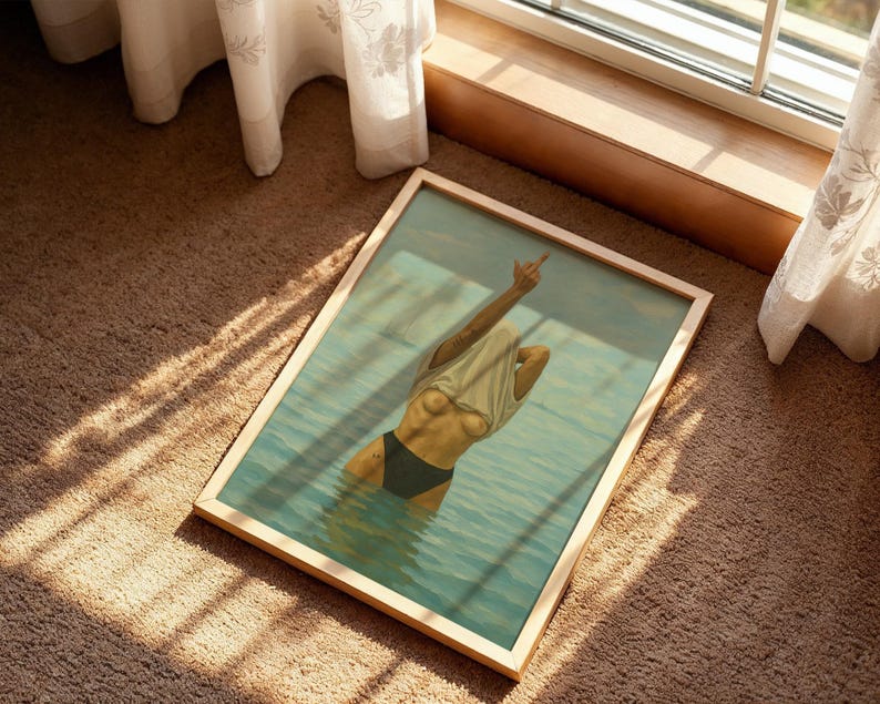 Puede incluir: Impresi&oacute;n art&iacute;stica enmarcada que representa a una persona en el agua, con una camiseta blanca y una parte inferior negra, con un brazo levantado en un gesto. La obra de arte est&aacute; enmarcada en un marco de madera clara, sobre una alfombra marr&oacute;n cerca de una ventana.