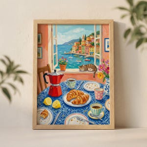 Puede incluir: Pintura enmarcada de una escena de desayuno con vista a la costa. Una cafetera roja, cruasanes, limones y tazas de café están sobre un mantel azul. Un gato descansa en un alféizar con vistas al mar.