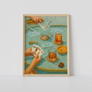 Puede incluir: Impresión enmarcada que representa una escena de juego de póquer. Se está sirviendo un martini y una mano sostiene naipes. Otros elementos incluyen un vaso de whisky, un cenicero y naipes sobre una mesa turquesa. Estética vintage.