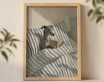 Puede incluir: Una impresión enmarcada muestra un galgo italiano gris leyendo un libro en la cama. El perro está bajo un edredón y una almohada a rayas azules y blancas. La obra de arte está en un marco de madera clara, creando una escena acogedora y caprichosa.