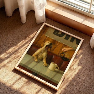 Puede incluir: Una impresi&oacute;n enmarcada que muestra un perro bostezando en una mesa de restaurante. La obra de arte representa una mano vertiendo caf&eacute; en una taza. El letrero del restaurante dice "DIN". El marco es de color claro, sobre una alfombra marr&oacute;n.