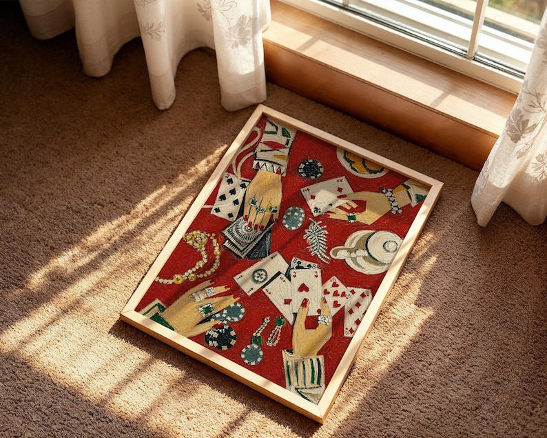 K&ouml;nnte beinhalten: Ein gerahmtes Kunstwerk mit rotem Hintergrund, das Spielkarten, mit Schmuck geschm&uuml;ckte H&auml;nde und Pokermarker zeigt. Das Kunstwerk befindet sich in einem hellen Holzrahmen und wird auf einem braunen Teppich pr&auml;sentiert.