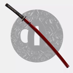 May include: A katana sword with a red scabbard and a black handle. The handle is wrapped with a black cord. The sword has a circular guard and a decorative design on the handle. The blade is not visible.