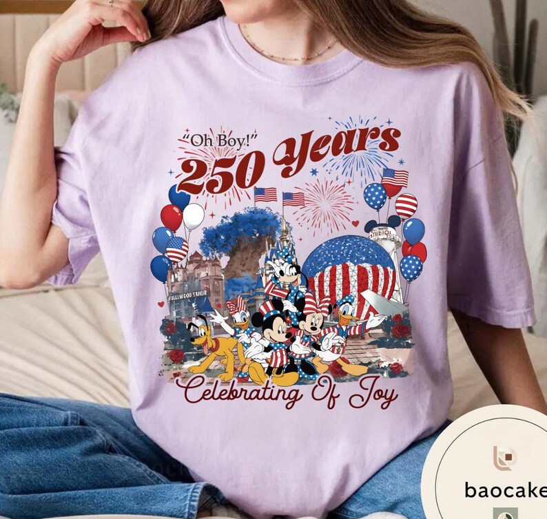 Puede incluir: Camiseta lila claro con un gr&aacute;fico que celebra 250 a&ntilde;os. El dise&ntilde;o incluye Mickey Mouse, Minnie Mouse, Donald Duck, Pluto, fuegos artificiales, globos y banderas americanas. El texto dice "Oh Boy!" y "Celebrating Of Joy."