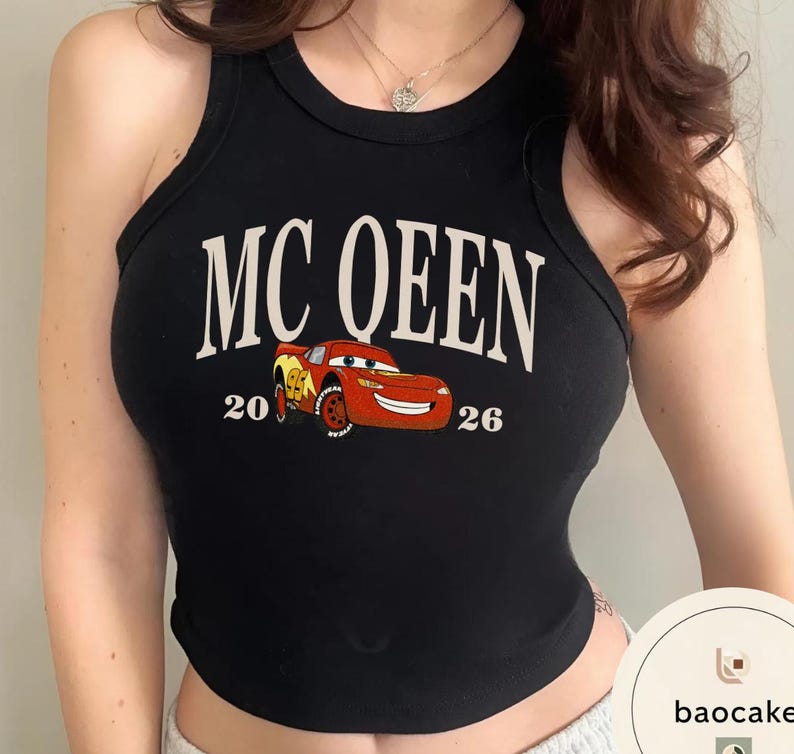 May include: Black tank top with the text "MC QUEEN" in white, featuring a cartoon image of a red race car. The numbers "20" and "26" are printed on either side of the car. A casual, sleeveless top.